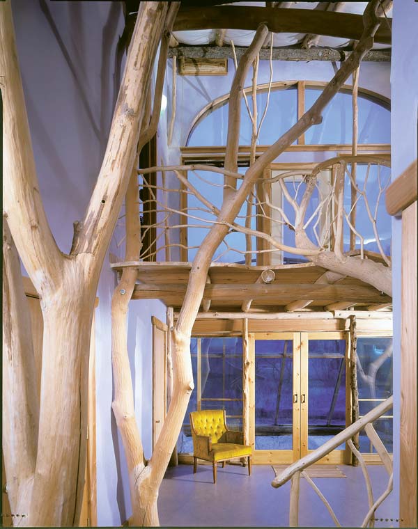 A mezzanine criss-crossed by graceful branches anchors the home's central space.